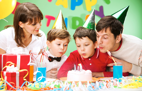 Child blowing candle during his birthday party