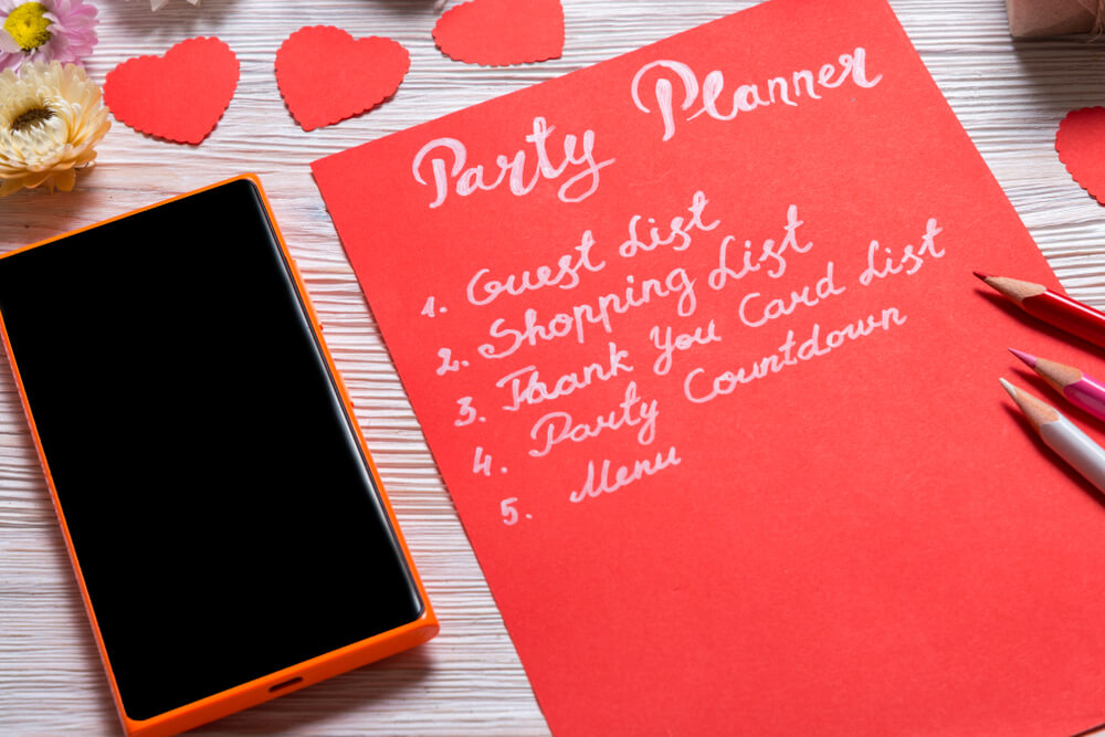 essential party supplies - party checklist on red paper with a red phone beside it